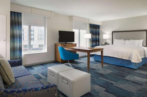 Cette chambre comprend un lit et un bureau. dans l'établissement Hampton Inn & Suites Rosemont Chicago O'Hare, à Rosemont