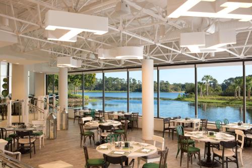 d'un restaurant avec des tables et des chaises et une vue sur la rivière. dans l'établissement Hilton Orlando Buena Vista Palace - Disney Springs Area, à Orlando