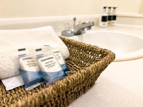 a basket of toothbrushes and a sink in a bathroom at The Downtown, a Coast Hotel in Dawson City