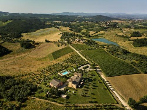 an aerial view of a farm with a house and a lake at Castello Del Nero - Podere San Filippo in Tavarnelle Val di Pesa