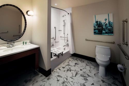 a bathroom with a sink and a toilet and a mirror at Hilton Brooklyn New York in Brooklyn