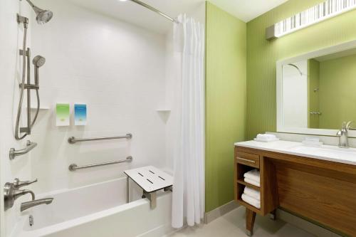 y baño con bañera, lavamanos y ducha. en Home2 Suites by Hilton Stillwater, en Stillwater