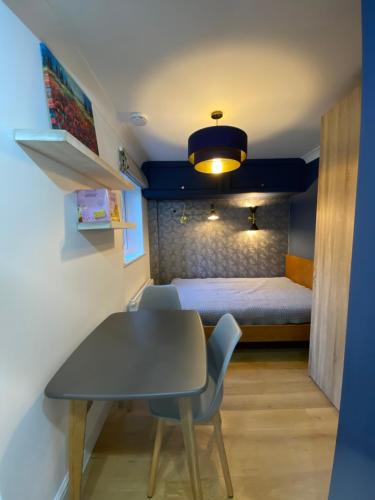 Cette petite chambre comprend une table et un lit. dans l'établissement Stylish 1-bed studio, à Londres