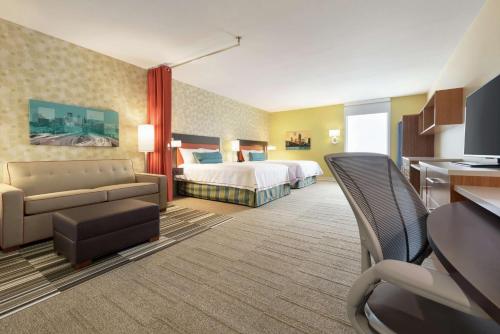 une chambre d'hôtel avec un lit et un canapé dans l'établissement Home2 Suites by Hilton Roseville Minneapolis, à Roseville