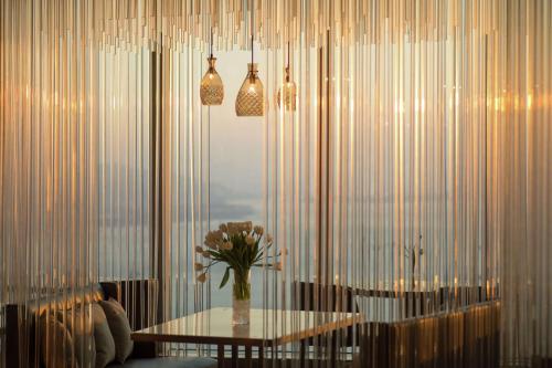 廈門的住宿－Conrad Xiamen-Free Mini Bar，一间设有桌子和花瓶的用餐室