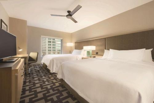 a hotel room with two beds and a flat screen tv at Homewood Suites by Hilton Chicago West Loop Fulton Mkt Area in Chicago