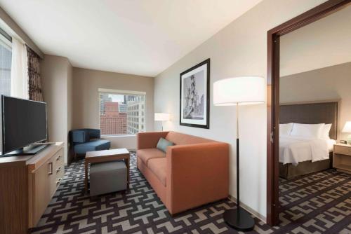 a hotel room with a couch and a bed at Homewood Suites by Hilton Chicago West Loop Fulton Mkt Area in Chicago