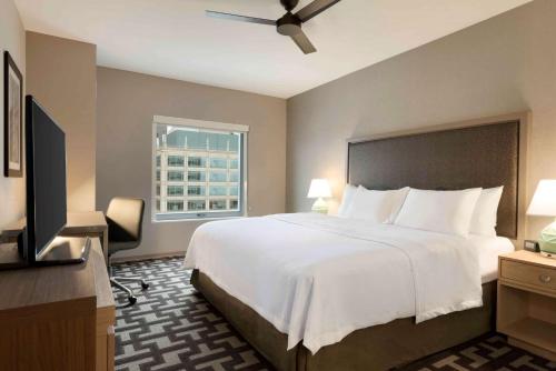 um quarto com uma grande cama branca e uma janela em Homewood Suites by Hilton Chicago Downtown West Loop em Chicago