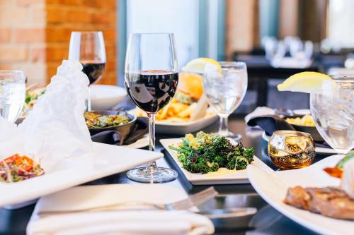 a table topped with plates of food and wine glasses at The Inverness Denver, a Hilton Golf & Spa Resort in Englewood