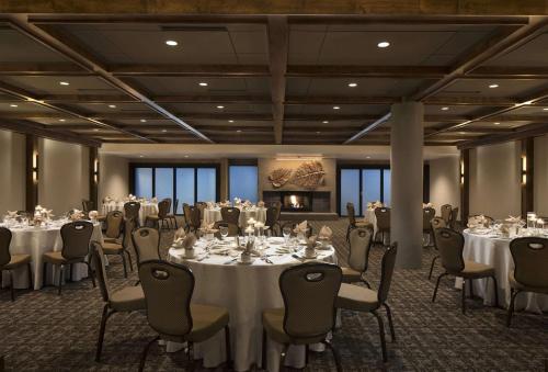 a conference room with tables and chairs in a room at The Inverness Denver, a Hilton Golf & Spa Resort in Englewood