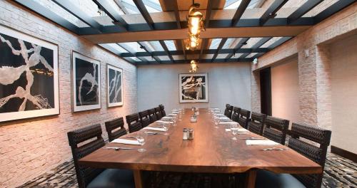 a long wooden table in a room with chairs at The Inverness Denver, a Hilton Golf & Spa Resort in Englewood