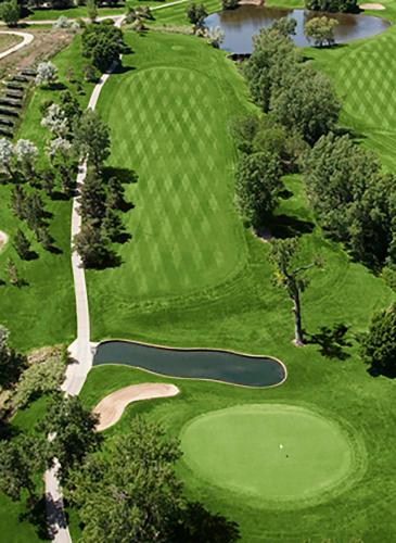 an overhead view of a golf course with a pond at The Inverness Denver, a Hilton Golf & Spa Resort in Englewood