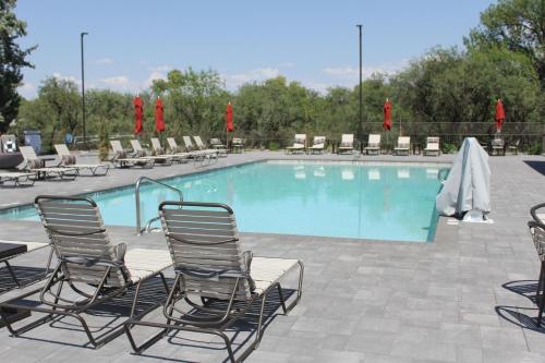 una piscina con sillas y un montón de plantas en Verde Ranch RV Resort, en Camp Verde