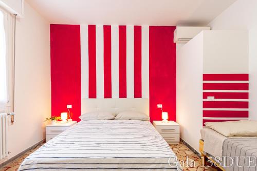 una camera da letto con strisce rosse e bianche sul muro di Gala158DUE Fair District a Bologna