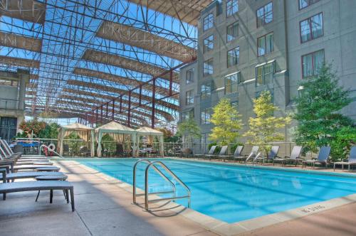 a large swimming pool with chairs and a building at St. Louis Union Station Hotel, Curio Collection by Hilton in Saint Louis