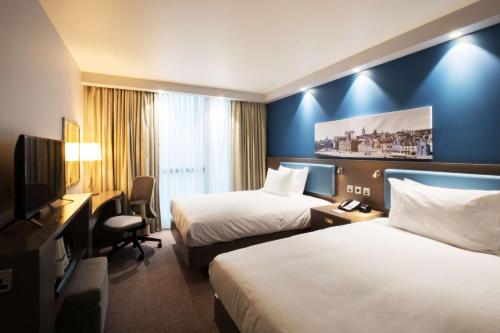 um quarto de hotel com duas camas e uma televisão em Hampton By Hilton Aberdeen Airport em Dyce