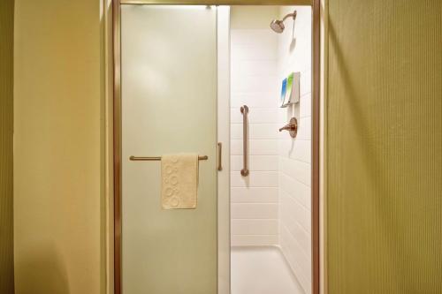 a bathroom with a shower with a towel on the door at Home2 Suites By Hilton Smyrna Nashville in Smyrna