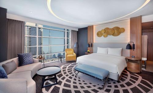 a bedroom with a bed and a living room at DoubleTree by Hilton Dubai - Business Bay in Dubai