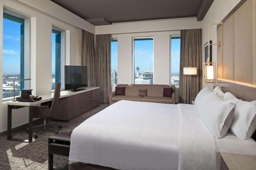 a bedroom with a bed and a desk with a television at H Hotel Los Angeles, Curio Collection By Hilton in Los Angeles