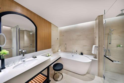a bathroom with two sinks and a tub and a shower at DoubleTree by Hilton Dubai - Business Bay in Dubai