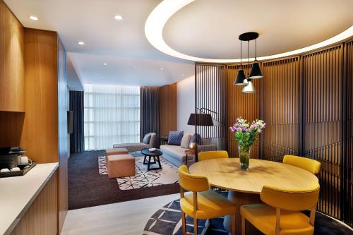 a living room with a table and yellow chairs at DoubleTree by Hilton Dubai - Business Bay in Dubai