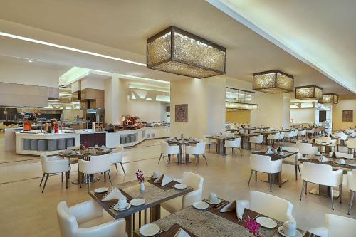 فندق ومركز مؤتمرات هيلتون مكة في مكة المكرمة: غرفة طعام مع طاولات وكراسي ومطعم