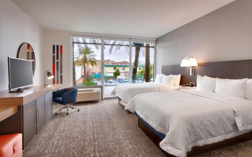 Hampton Inn & Suites Anaheim Resort Convention Center في أنهايم: غرفه فندقيه سريرين وتلفزيون