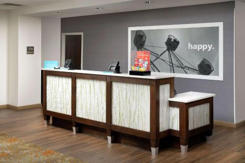 a lobby with a reception desk with a happy sign at Hampton Inn Denver Tech Center South in Centennial