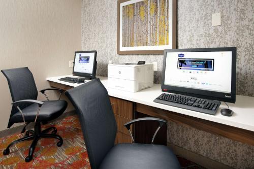 een bureau met een computer en 2 stoelen bij Hampton Inn Denver Tech Center South in Centennial