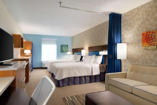 een hotelkamer met een bed en een bank bij Home2 Suites By Hilton Joliet Plainfield in Joliet