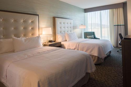 a hotel room with two beds and a chair at Homewood Suites By Hilton Allentown Bethlehem Center Valley in Center Valley