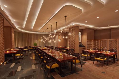a large dining room with tables and chairs at Conrad Bengaluru in Bengaluru
