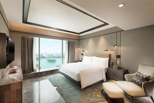 a hotel room with a bed and a large window at Conrad Bengaluru in Bengaluru