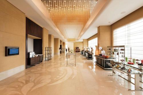 a large lobby with a chandelier and a store at Conrad Bengaluru in Bangalore