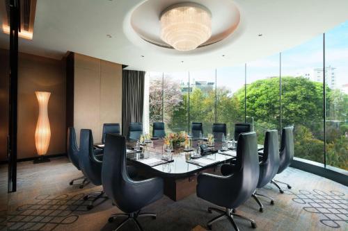 a conference room with a long table and chairs at Conrad Bengaluru in Bengaluru