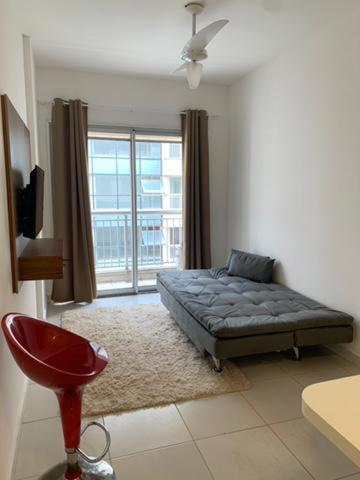 a bedroom with a bed and a large window at Flat Itaguai in Itaguaí