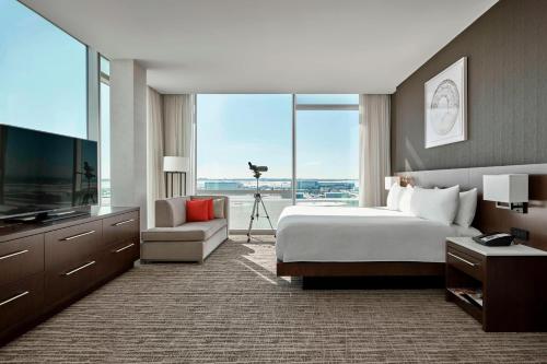 Calgary Airport Marriott In-Terminal Hotel في كالغاري: غرفة فندقية بسرير ونافذة كبيرة