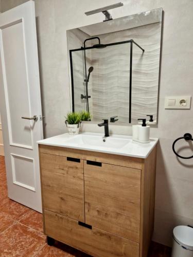 ein Bad mit einem Waschbecken und einem Spiegel in der Unterkunft Piso en Jarandilla de la Vera in Jarandilla de la Vera