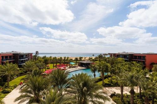 - une vue aérienne sur un complexe avec une piscine et l'océan dans l'établissement Hilton Cabo Verde Sal Resort, à Santa Maria