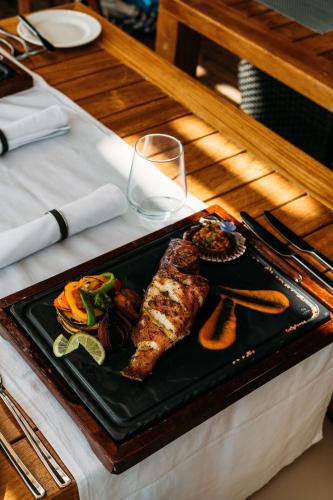 a plate of food with meat and vegetables on a table at Hilton Cabo Verde Sal Resort in Santa Maria