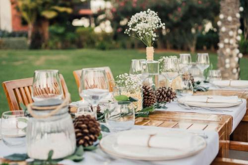 a long table with plates and glasses and pine cones at Hilton Cabo Verde Sal Resort in Santa Maria