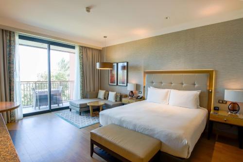 a hotel room with a large bed and a balcony at Hilton Cabo Verde Sal Resort in Santa Maria