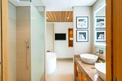 a bathroom with a shower and a sink and a tub at Hilton Cabo Verde Sal Resort in Santa Maria