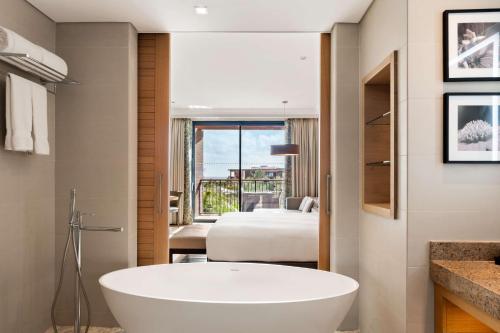 a bathroom with a tub and a bedroom with a bed at Hilton Cabo Verde Sal Resort in Santa Maria