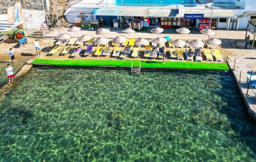 an overhead view of a swimming pool with chairs and umbrellas at Hotel Bleu Nuit in Bodrum City
