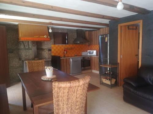 une cuisine avec une table en bois et une salle à manger dans l'établissement Beiral da Marfida, à Amarante