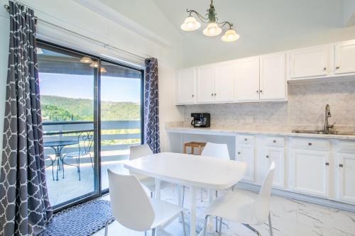 a kitchen with white cabinets and a table and chairs at Serene Views Community Pool in Gatlinburg