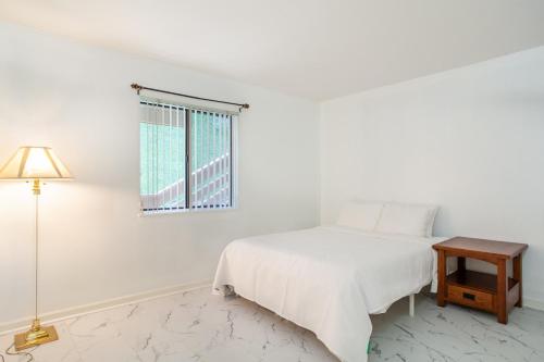 a white bedroom with a bed and a window at Serene Views Community Pool in Gatlinburg