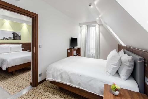 a hotel room with two beds and a mirror at Hampton By Hilton Gdansk Oliwa in Gdańsk