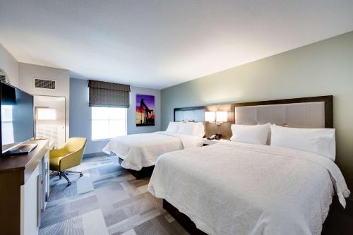 a hotel room with two beds and a desk at Hampton Inn & Suites Fort Worth Downtown in Fort Worth